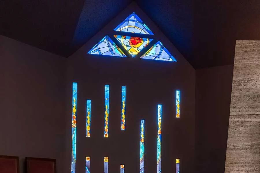triangle stained glass window above with seven slender panels beneath