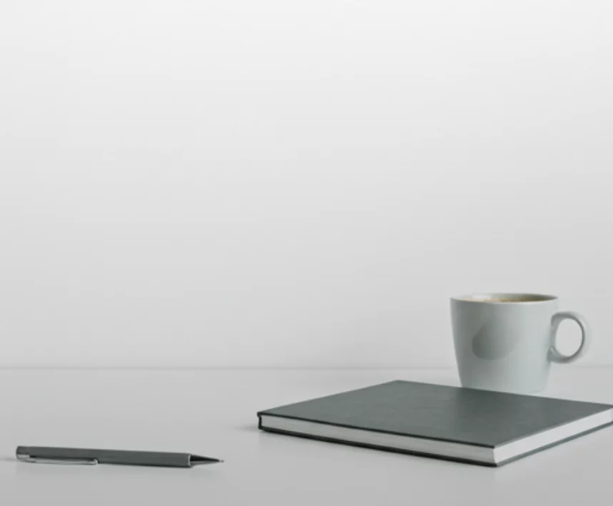 Minimalist desk setup with coffee and notebook