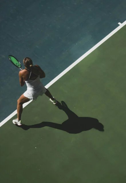 Mulher jogando tênis em quadra de saibro, com a raquete. Imagem para site de esporte ou portfólio de web designer