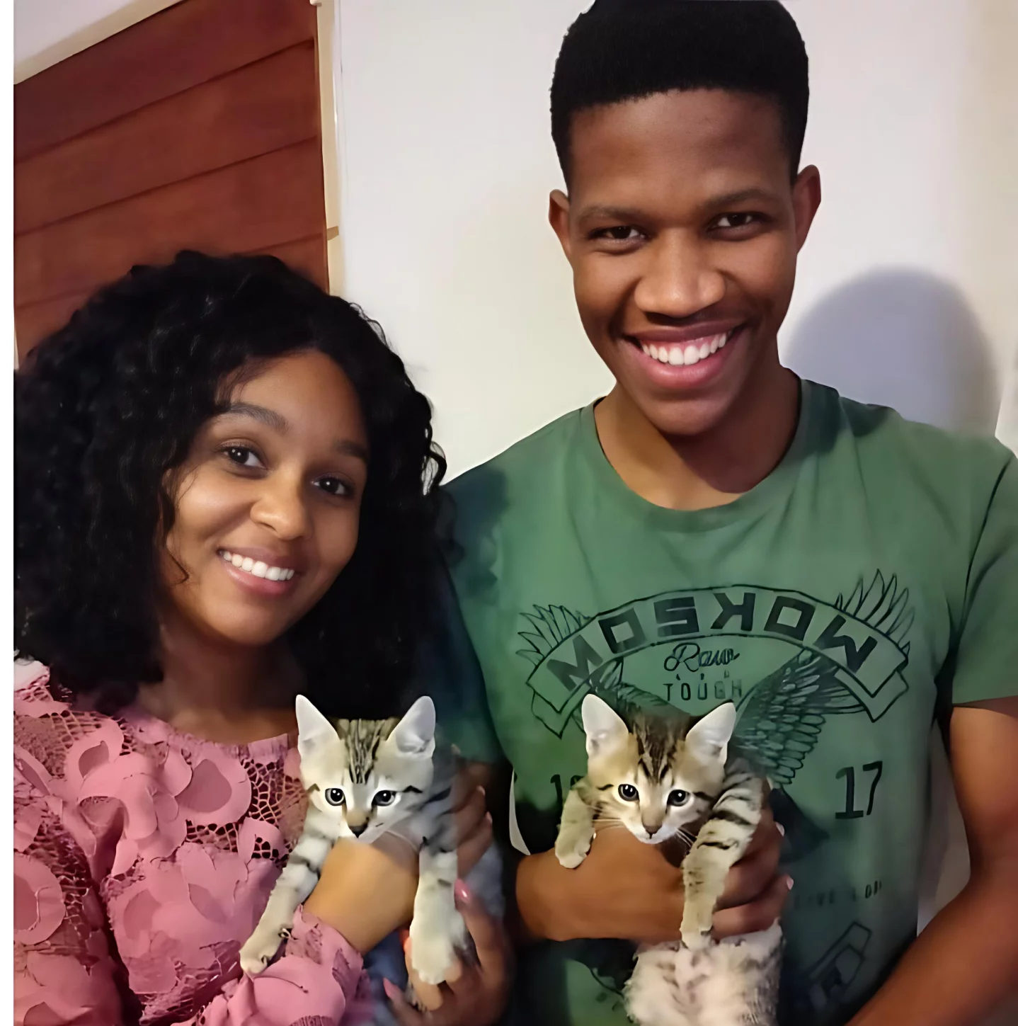 Adoption four: Cats. Two little precious Tabby kittens were adopted by a young couple. The woman to the left is holding one of the kittens and her much taller boyfriend is holding the other kitten. They are at home and are both smiling as very happy about their new furry babbies!