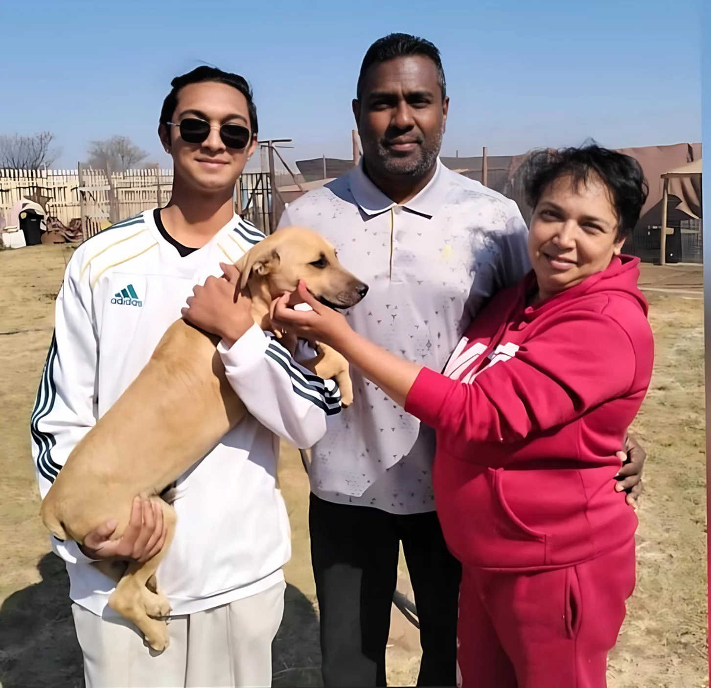 A happy family that adopted a doggy from our organisation. The family consists out of a happy married couple, their adult son and now their new furry friend. The dog is a male dog that we were sheltering. He is light brown, very strong and medium sized. He fortunately did not have a history of abuse before being adopted. The image works well with the visual appeal of the website since the clear blue sky works well with the teal-blueish colour of the website and the mother has a cherry red outfit on that matches the colour of the cherry red buttons of this site.