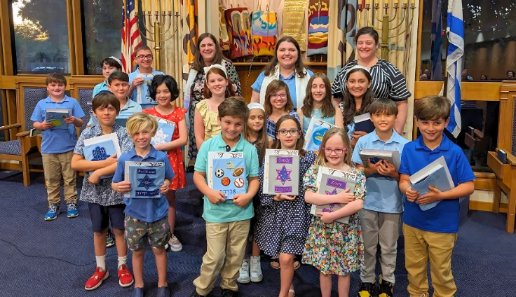 kids around an unfurled torah scroll