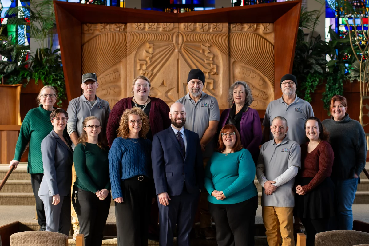 staff posing in front of new beth emeth sign