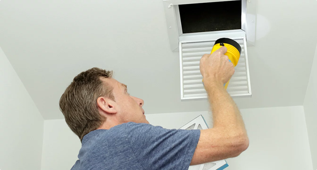 Technician cleaning vent