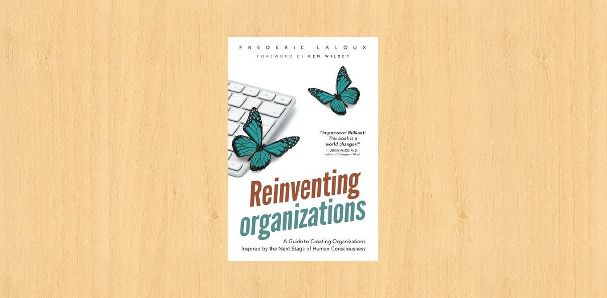 Reinventing organizations book cover placed on the desk.