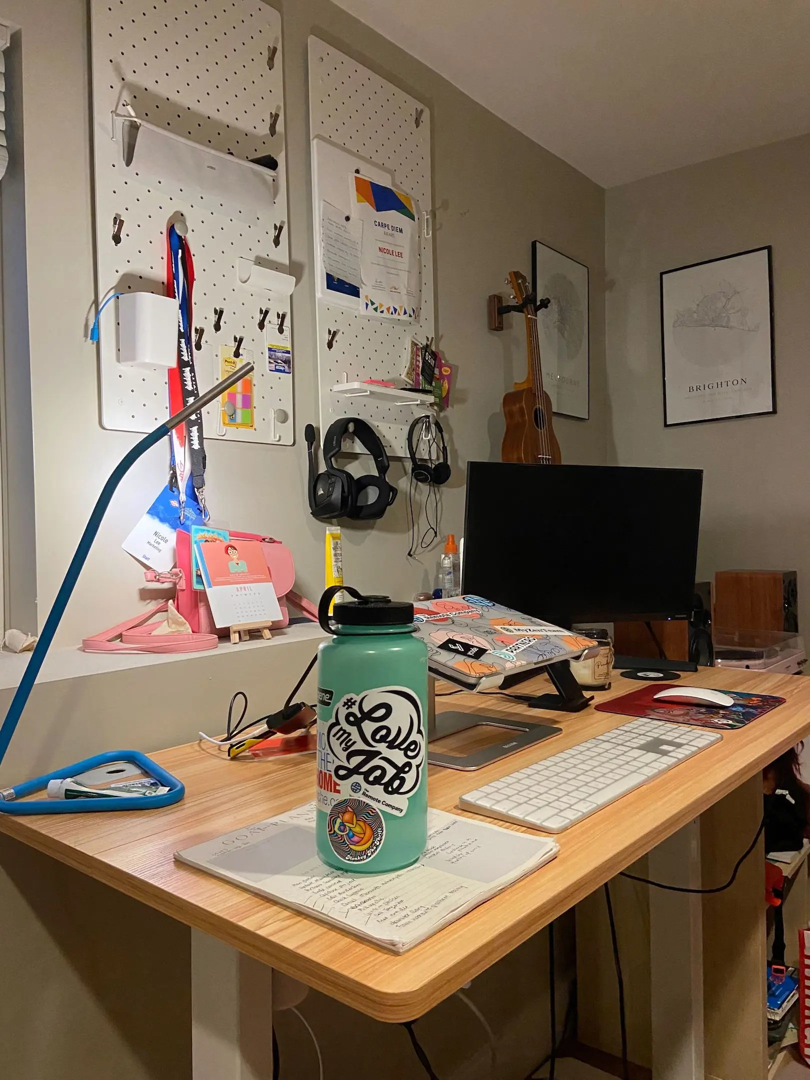 wfh setup for music lovers - ukulele, headphones, speakers, vinyl player, external monitor, Apple magic mouse and keyboard, and Macbook can be seen on an adjustable standing desk